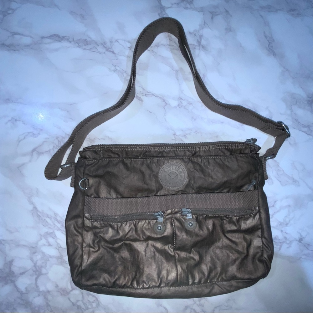 Kipling crossbody bag with exterior compartment and adjustable strap.